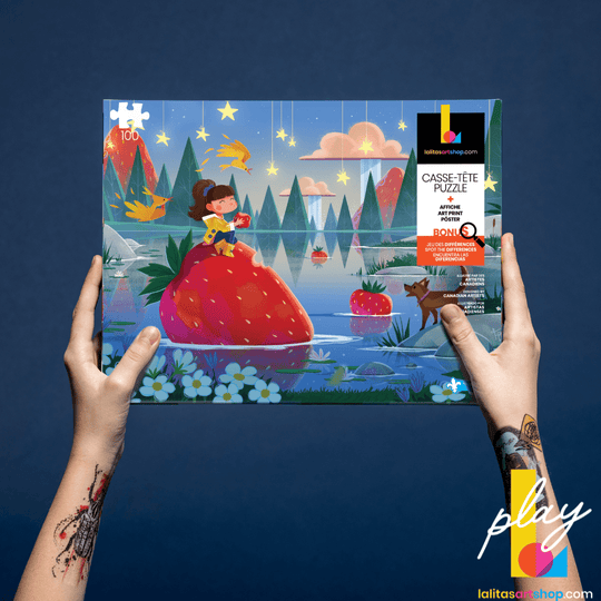 Hands holding the box of the Strawberry Mist 100-piece puzzle, showcasing the artwork and &
