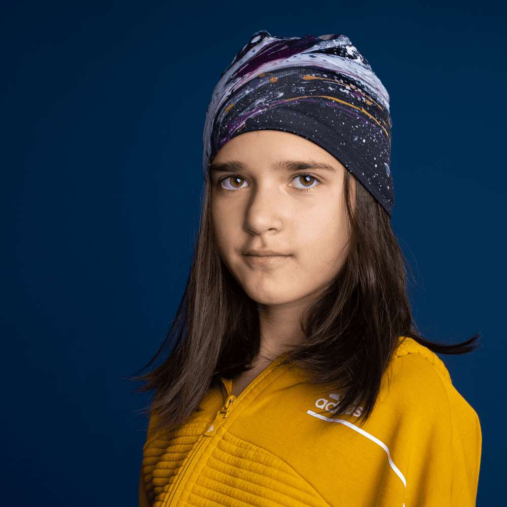 Jeune fille portant la tuque Abracadabra comme bandeau, révélant le motif artistique abstrait.