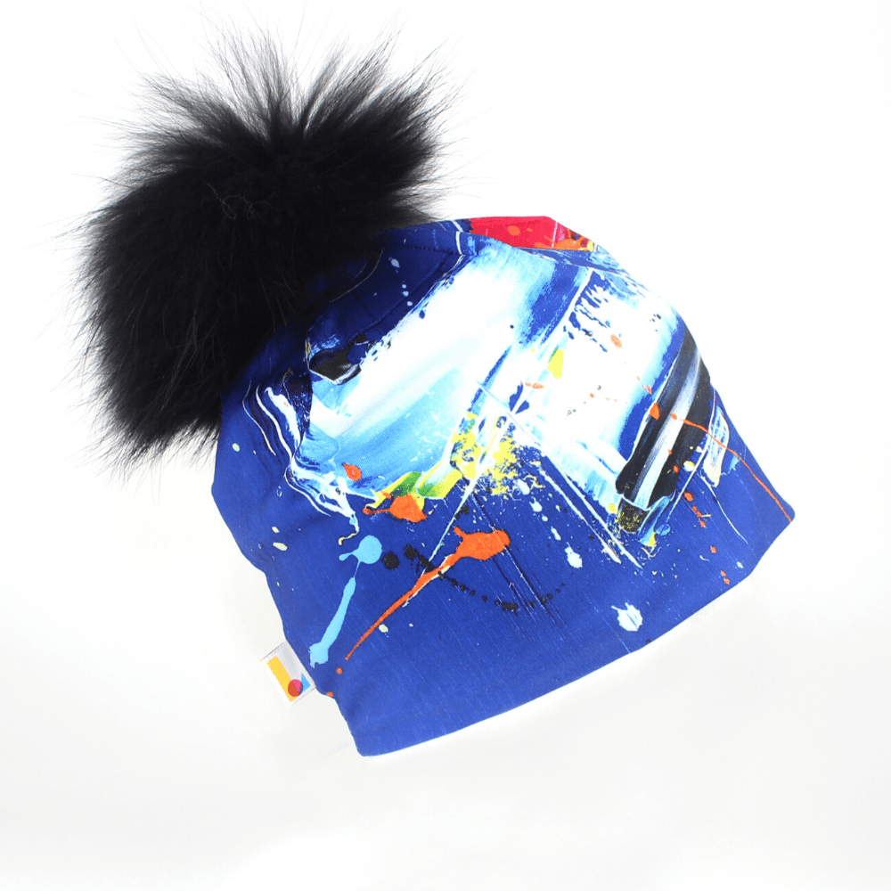 Tuque Bleue Abstrait avec un gros pompon noir et moelleux sur fond blanc.
