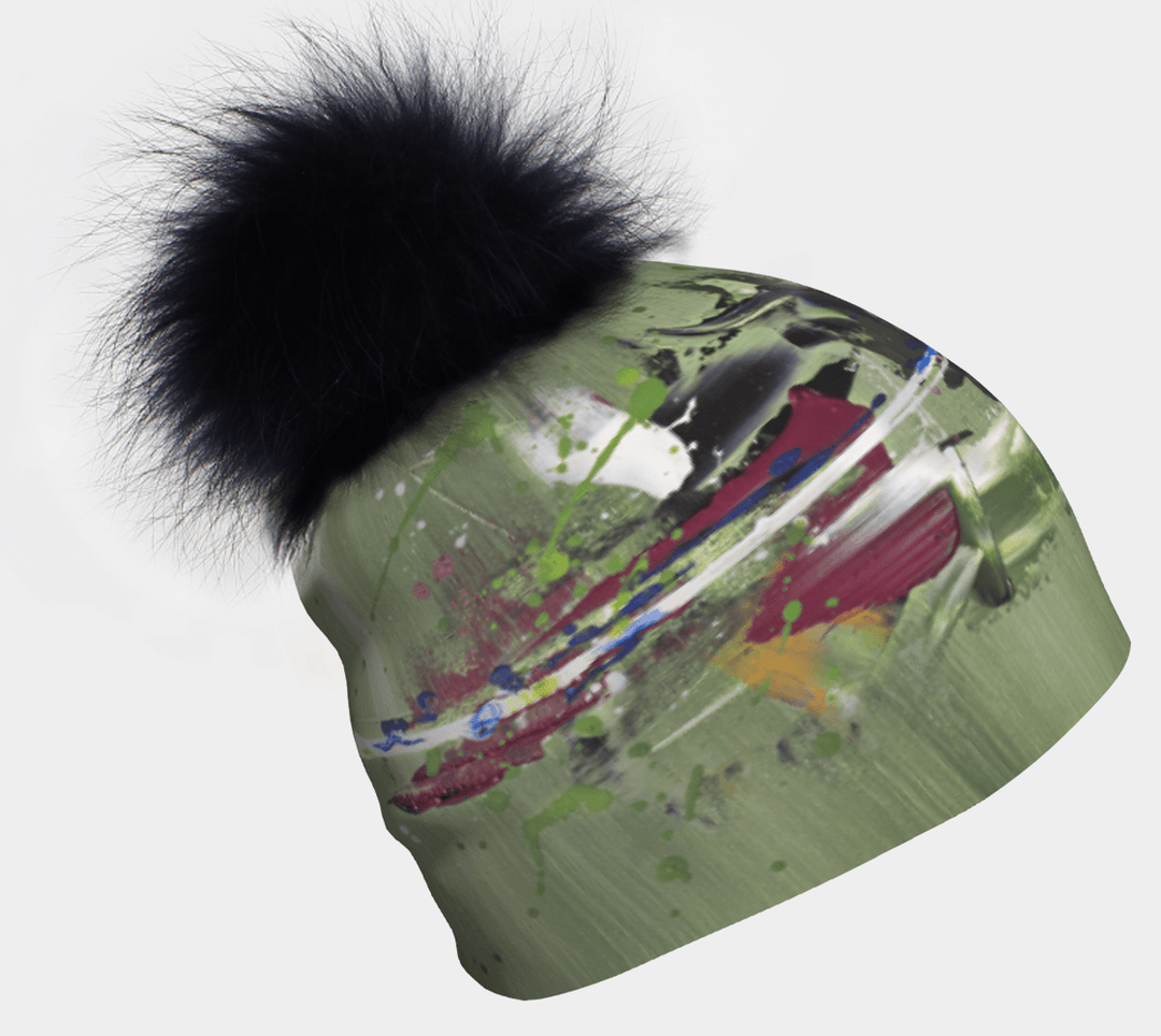 Amazonia Beanie with a large black fluffy pom-pom and a green abstract art print.