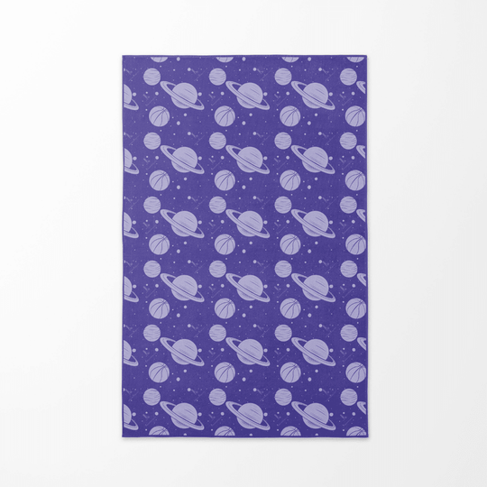 Back side of the Cosmic Slam beach towel with a repeating pattern of purple planets and basketballs on a starry background.