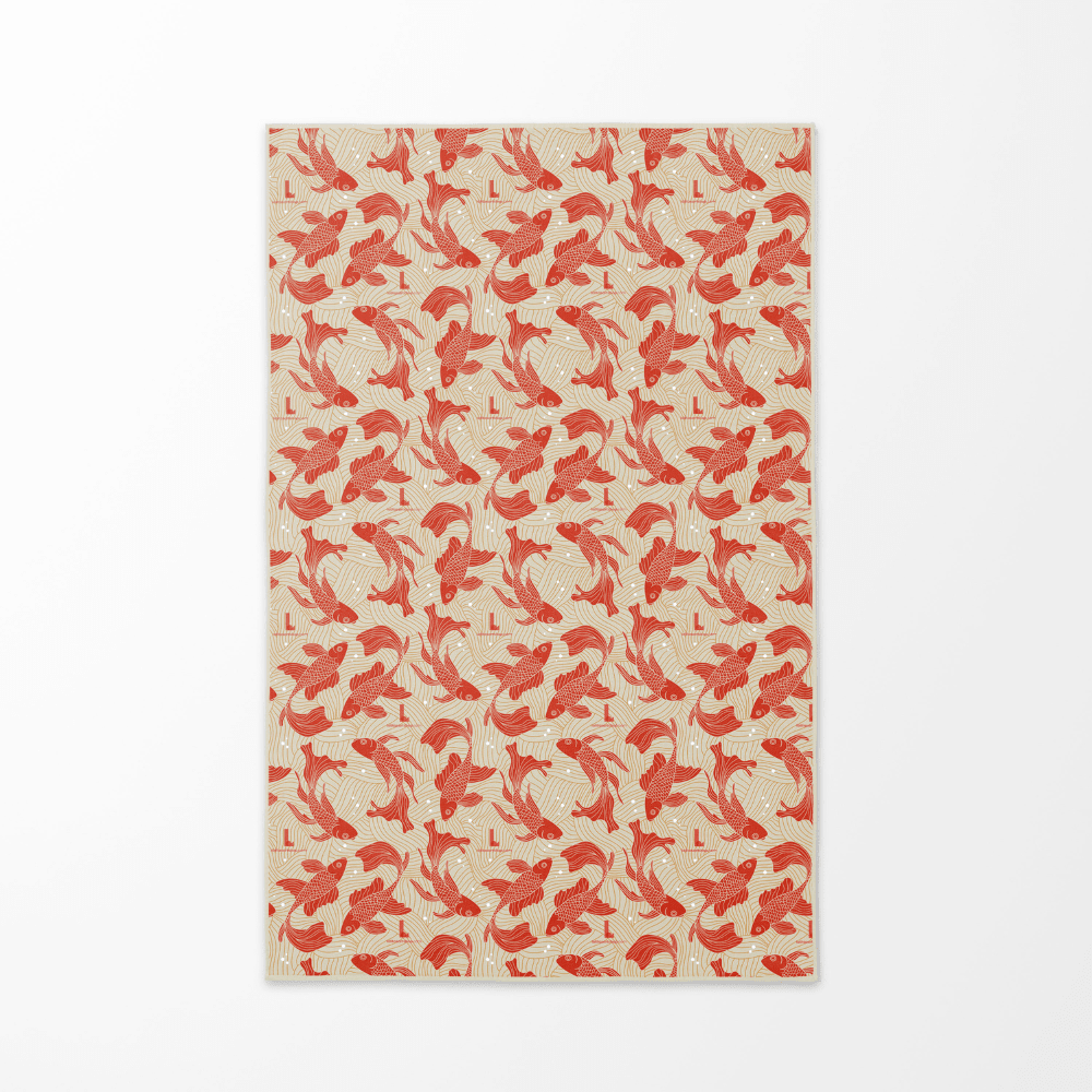 Le côté réversible de la serviette Guerrière Pacifique, affichant un motif répétitif de poissons koi rouges sur fond beige.