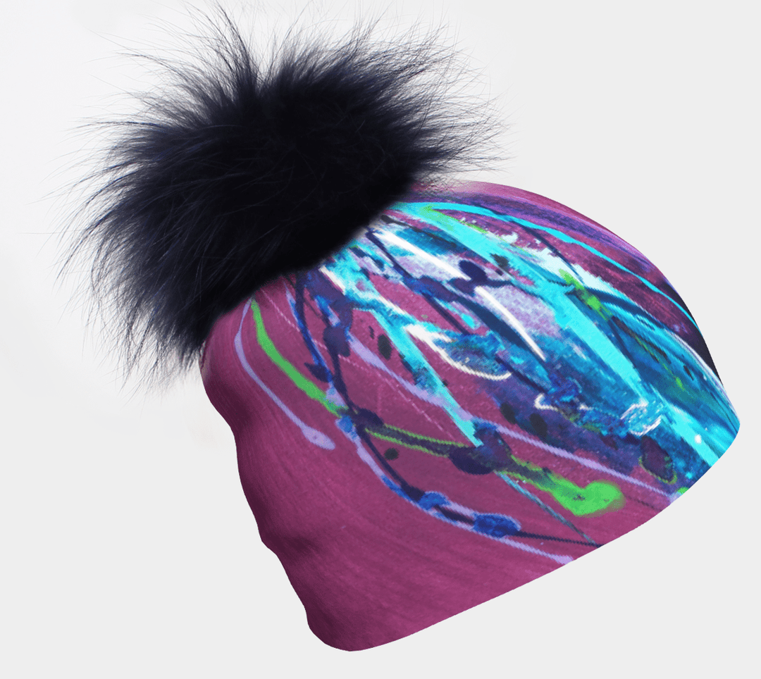 Gros plan de la tuque Hope avec pompon, montrant son imprimé abstrait vibrant et son pompon noir moelleux.