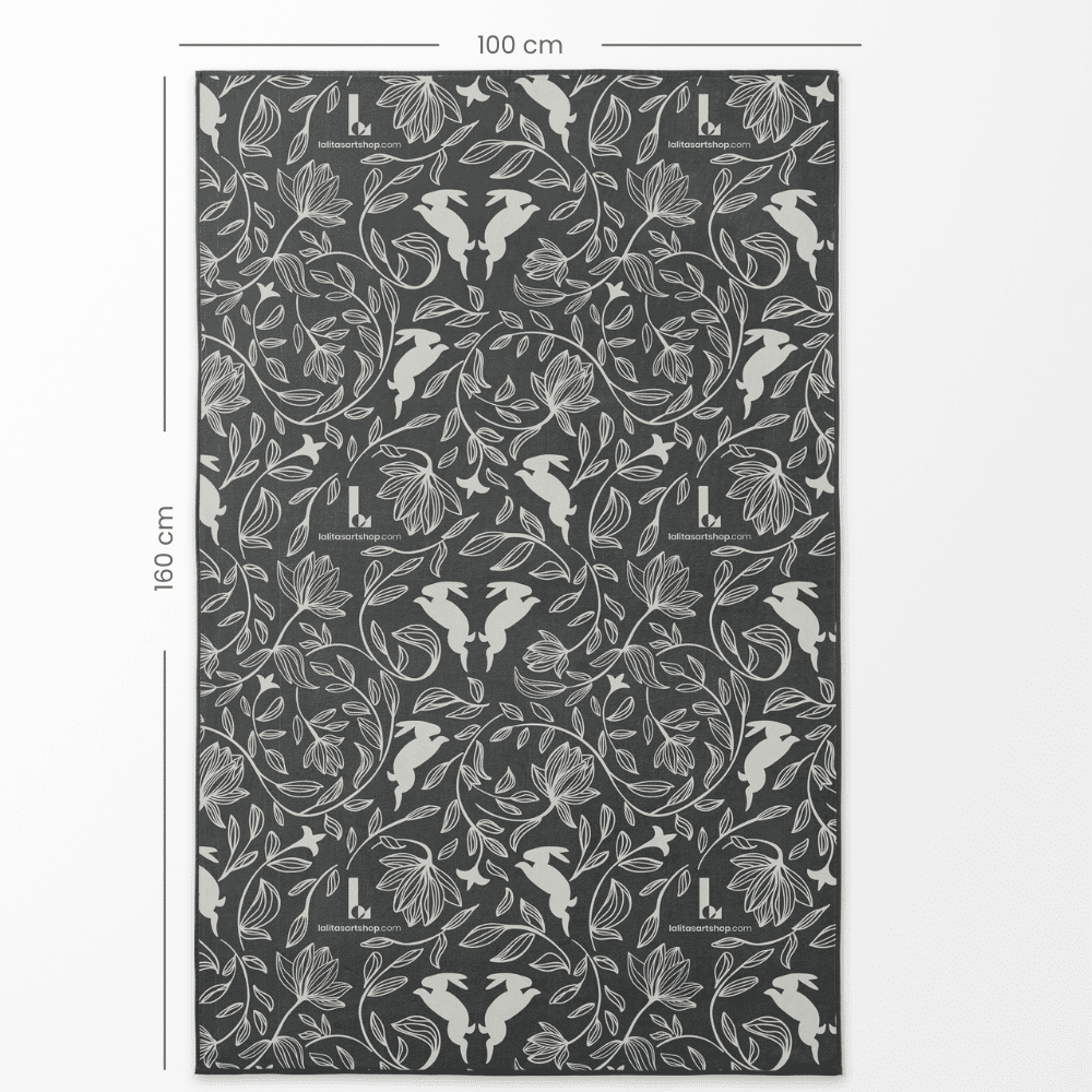 Gros plan du côté à motif de la grande serviette artistique réversible, montrant le design de lapin et de fleurs avec les dimensions de 100 cm par 160 cm.