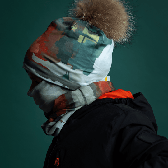 Side profile of a young boy wearing the Lachine Beanie and neck tube, with a hint of orange lining visible.