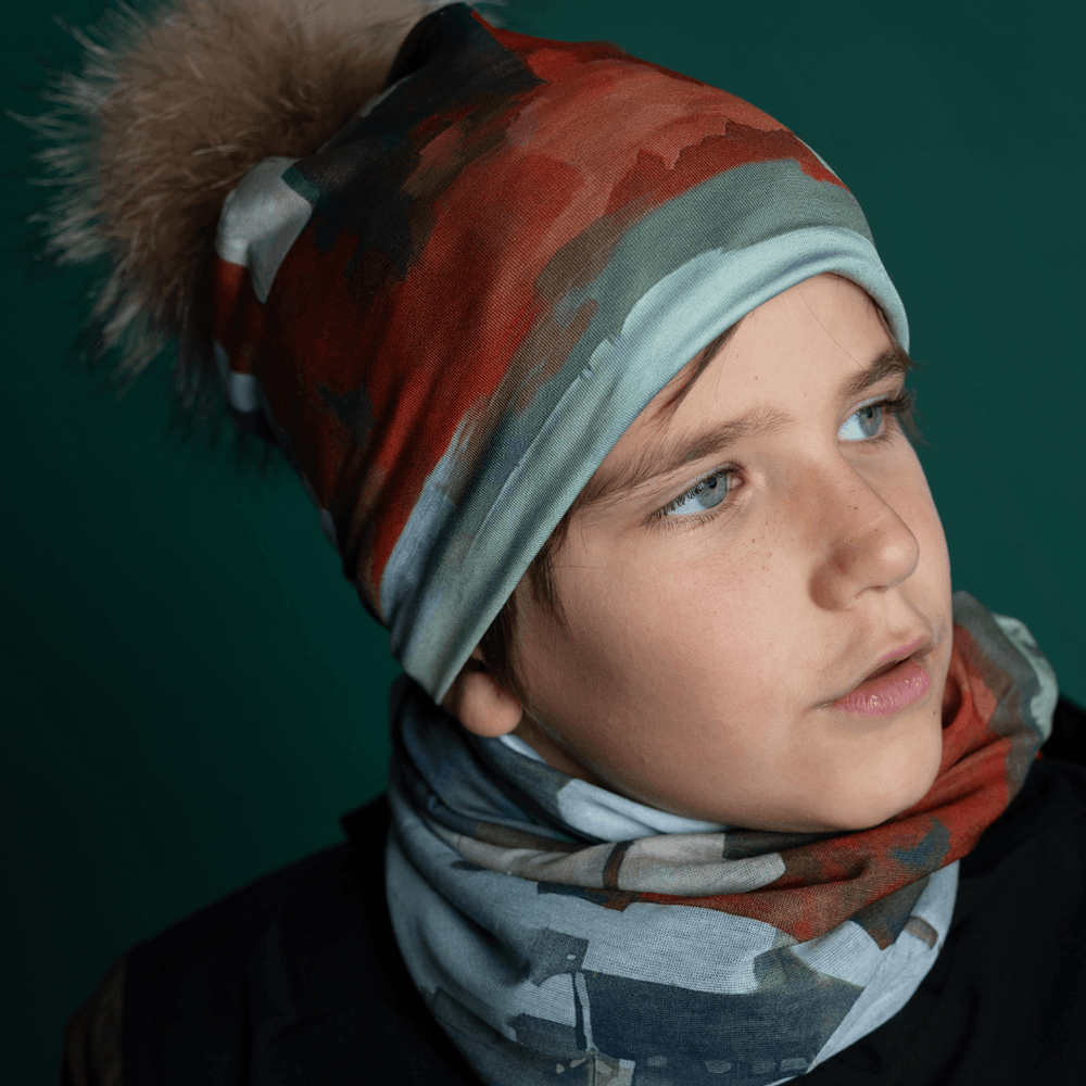 Jeune garçon portant la tuque Lachine et cache-cou assorti, regardant sur le côté.