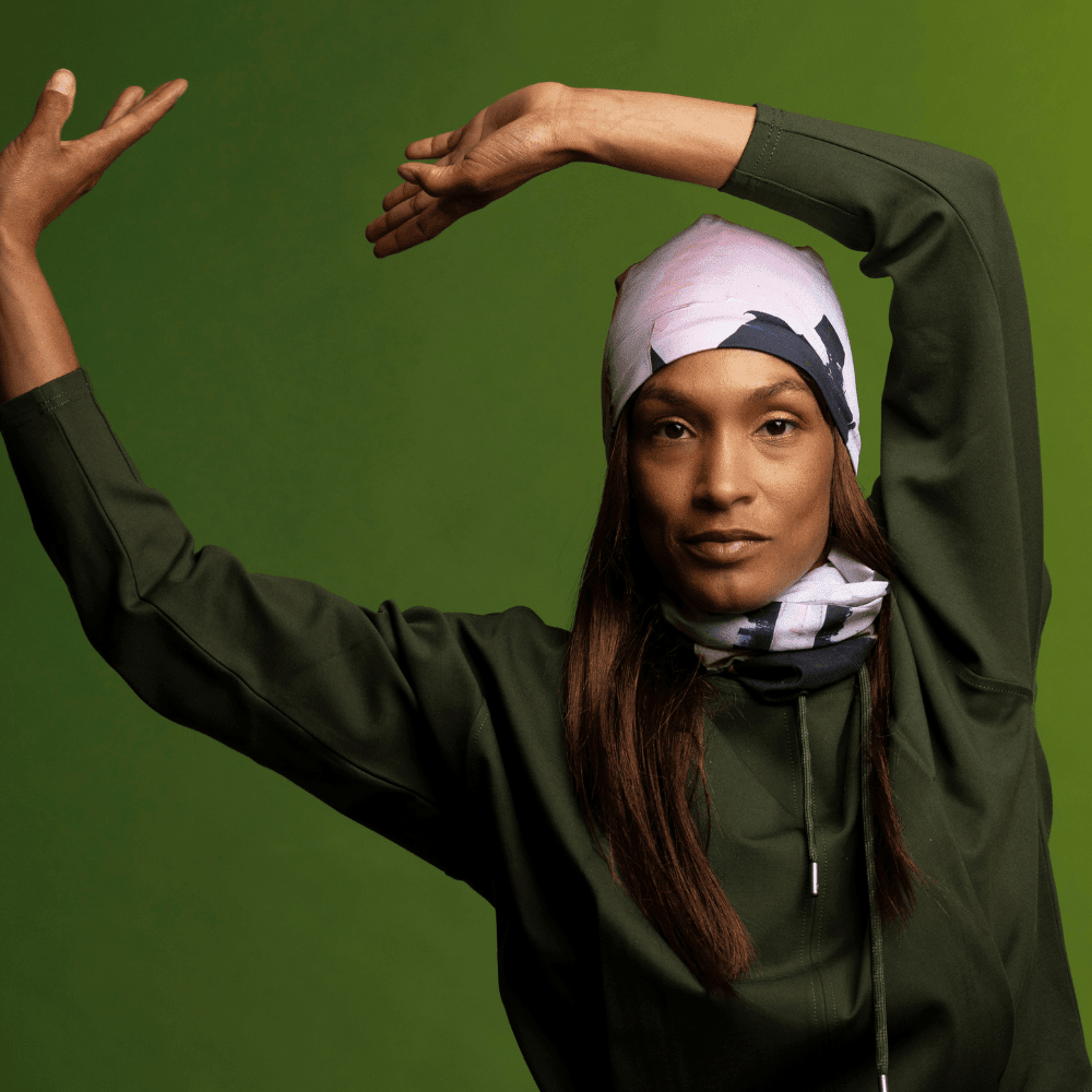 Mannequin portant un haut vert foncé, posant les bras levés, avec un imprimé matelassé moderne en bandana.