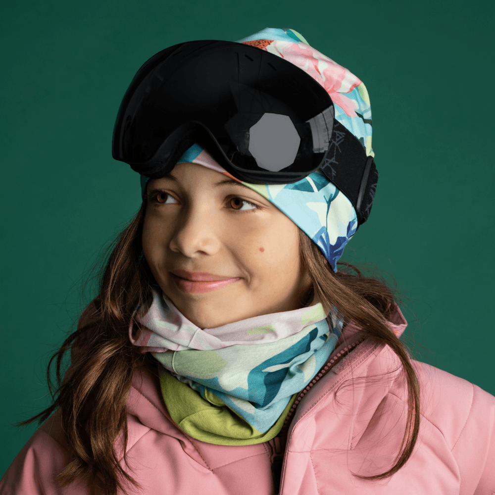 Young girl wearing the Pastel Flowers Beanie and a matching neck gaiter with ski goggles.