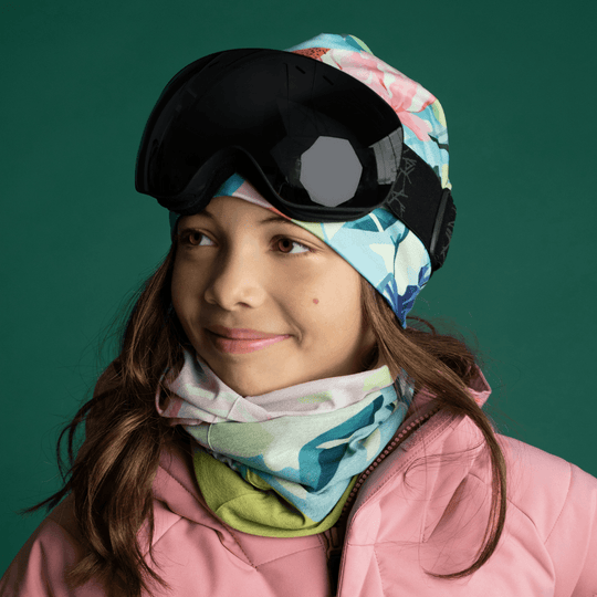 Young girl wearing the Pastel Flowers Beanie and a matching neck gaiter with ski goggles.