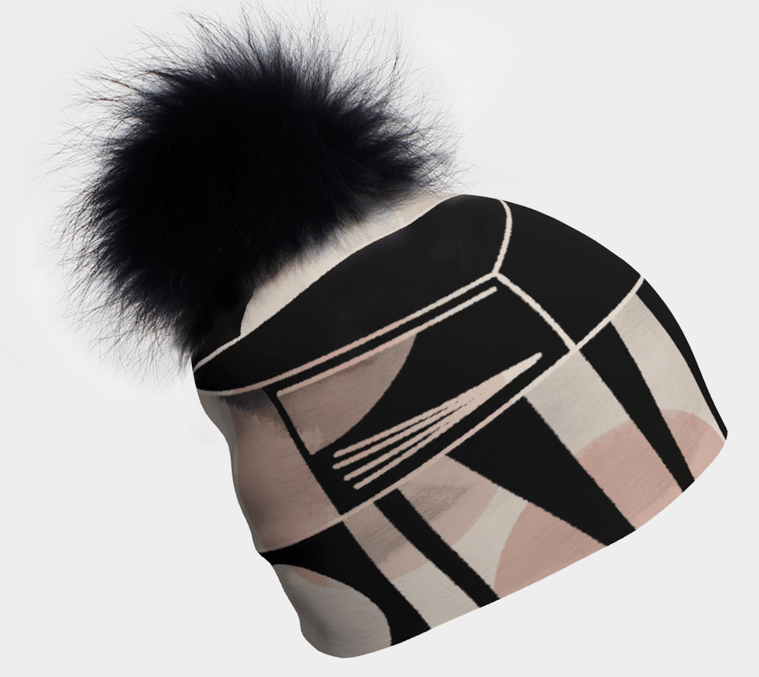 Tuque Géométrique Rose et Noire avec un gros pompon noir moelleux sur le dessus, montrant un motif géométrique abstrait.