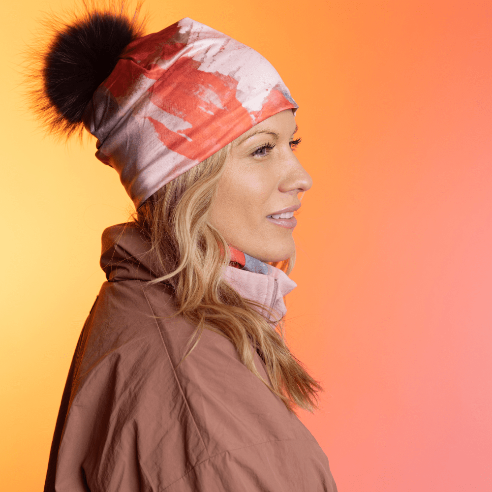 Woman wearing the Pink &amp; Flames Beanie with a black pompom in profile.