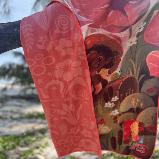 La serviette de plage Pluie Joueuse pour enfants drapée sur une branche d&