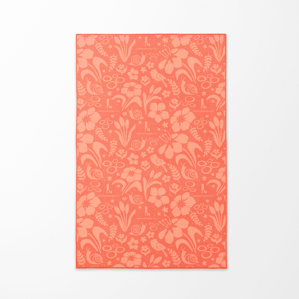 Le motif floral corail de la serviette de plage Pluie Joueuse pour enfants affiché à plat sur un fond blanc.