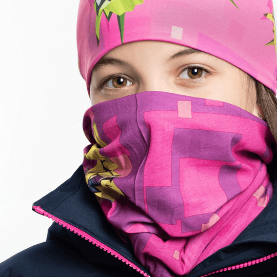 Femme portant un cache-cou rose avec un imprimé papillon géométrique, remonté sur son nez et sa bouche.