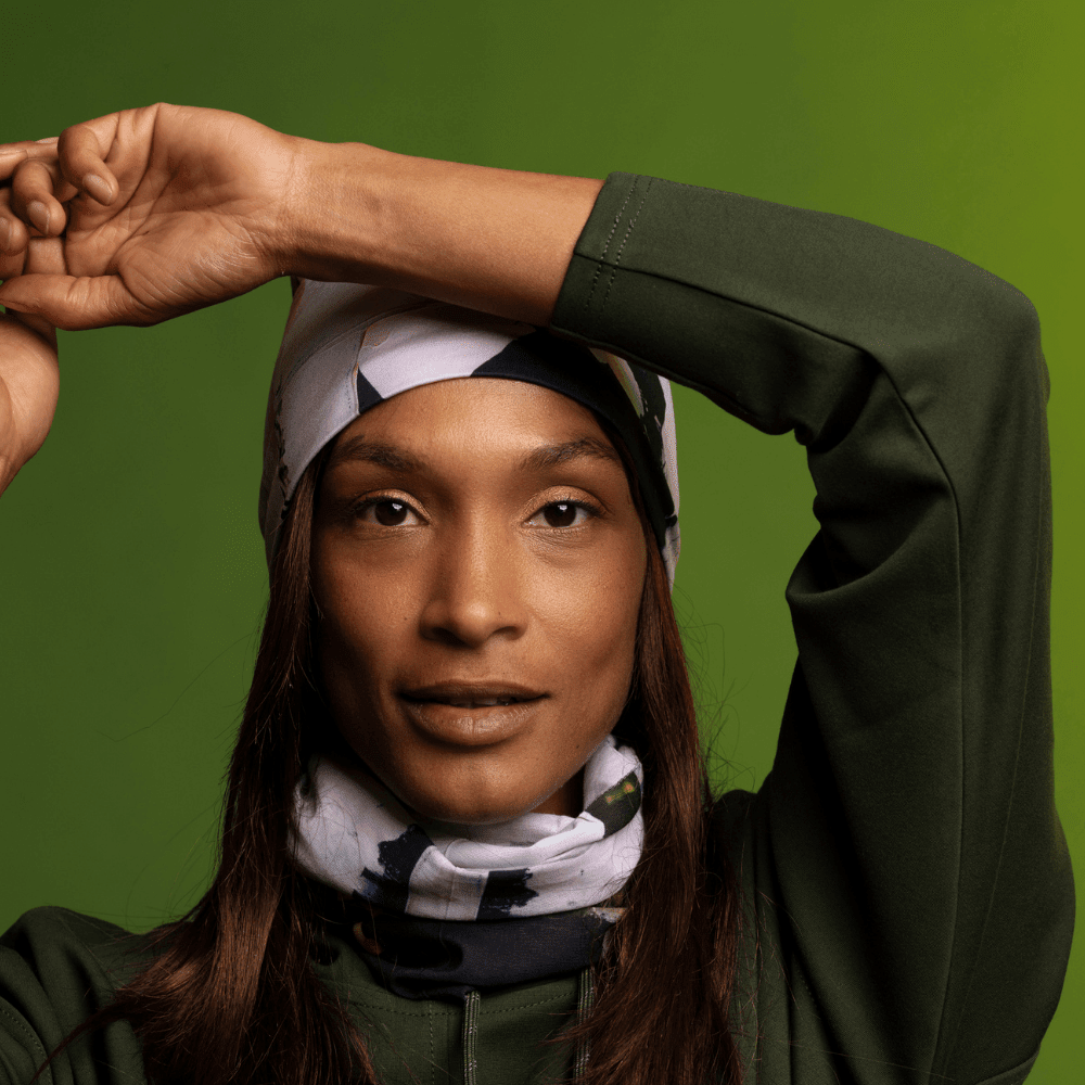 Femme portant le Tube multifonction POLAR Motif matelassé moderne en tuque et cache-cou, style avec un sweat à capuche vert.