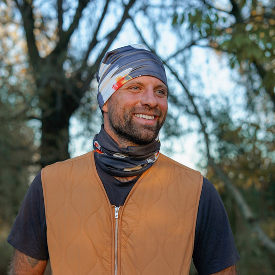 Homme portant un tube bandana en bandeaux et cache-cou, souriant à l&