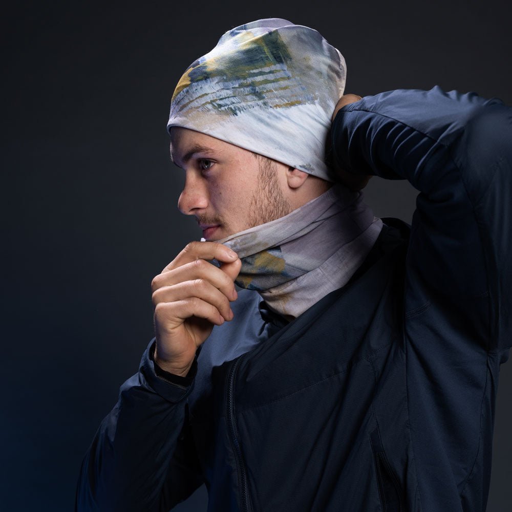 A person putting on the Sand Multifunctional Tube as a beanie and a neck warmer.