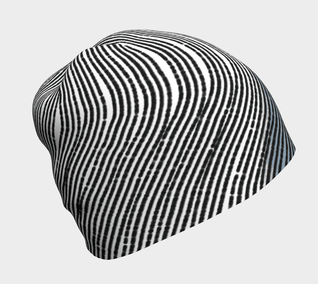 Une tuque blanche et noire à rayures abstraites vue de côté.