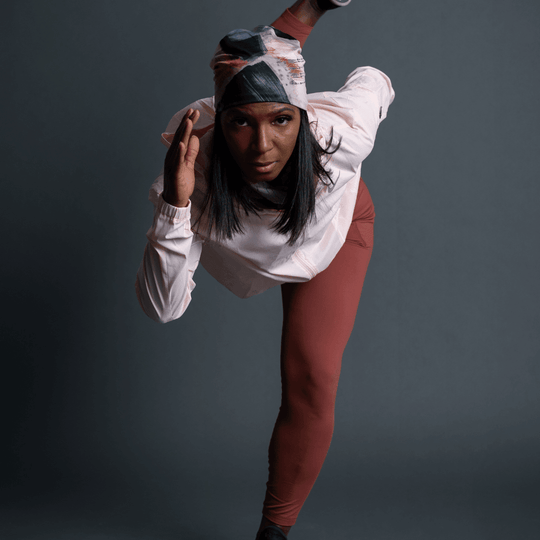 Femme en tenue sportive portant la Tuque Vie en Rose, adoptant une pose dynamique.