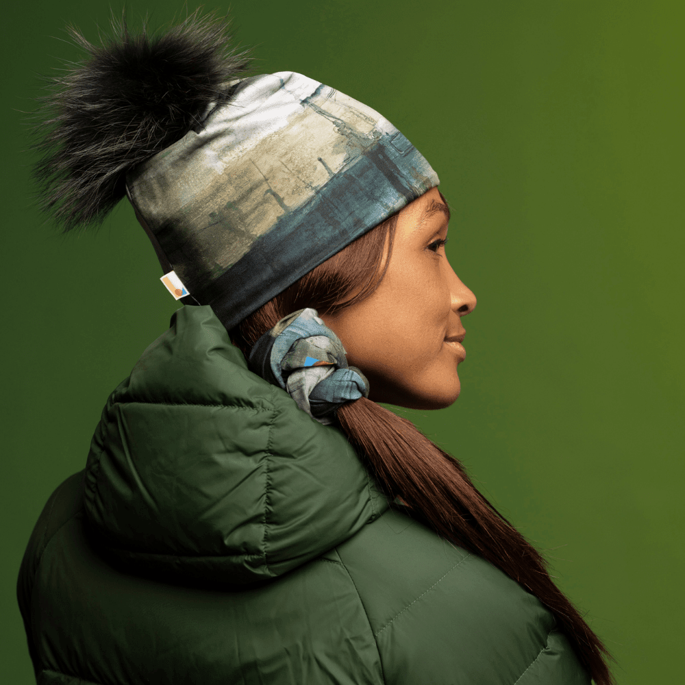 Une femme portant la Tuque Murale à Pompon et un manteau d&