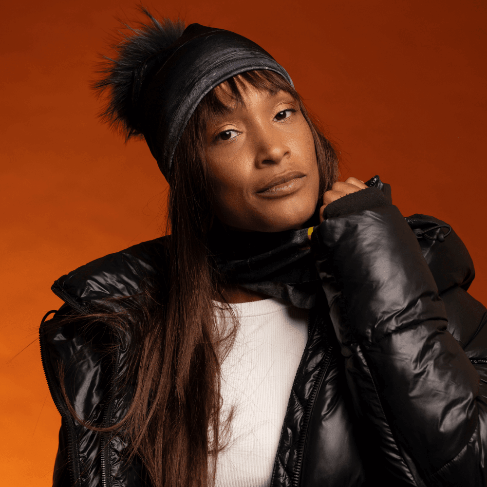 Femme portant une tuque noire avec pompon noir et un cache-cou assorti