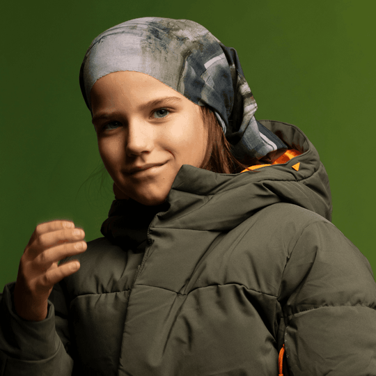 Jeune fille portant le Tube Multifonction Murale en bandeau avec une veste matelassée verte.