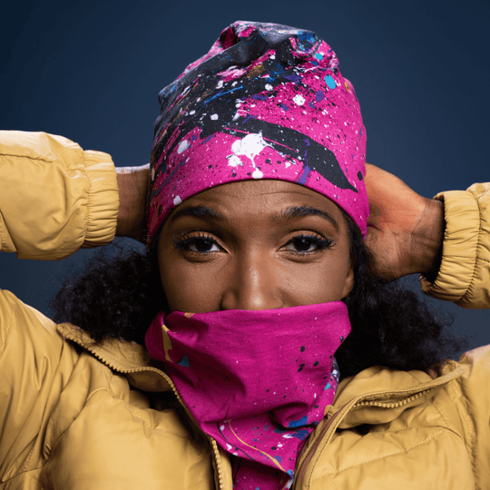 Woman wearing the pink abstract print tube pulled up as a face covering.