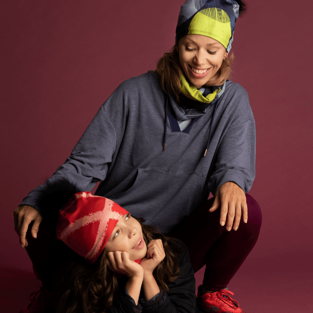 Mère et enfant portant des tuques et des cache-cous assortis à Motifs Jaunes dans un studio.
