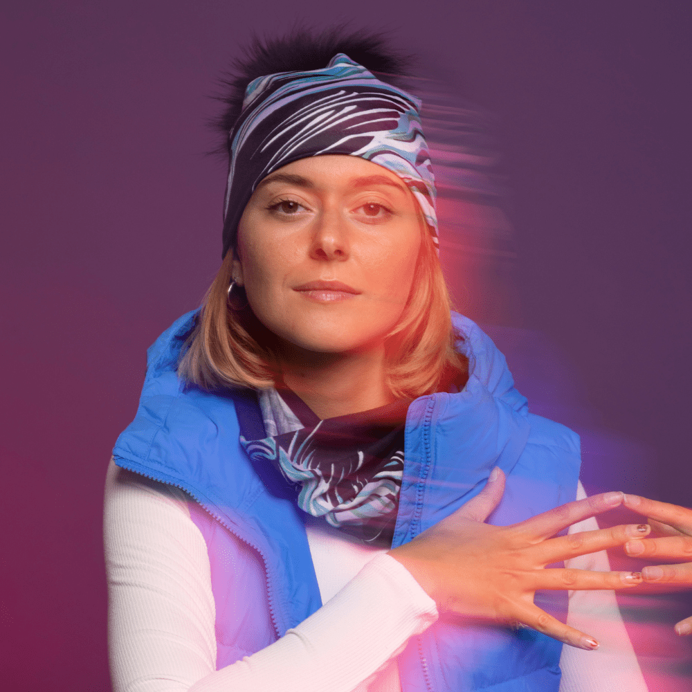 Sportive woman wearing the Heron Black and Blue Multifunctional tube with assorted pompom beanie for Lalita&