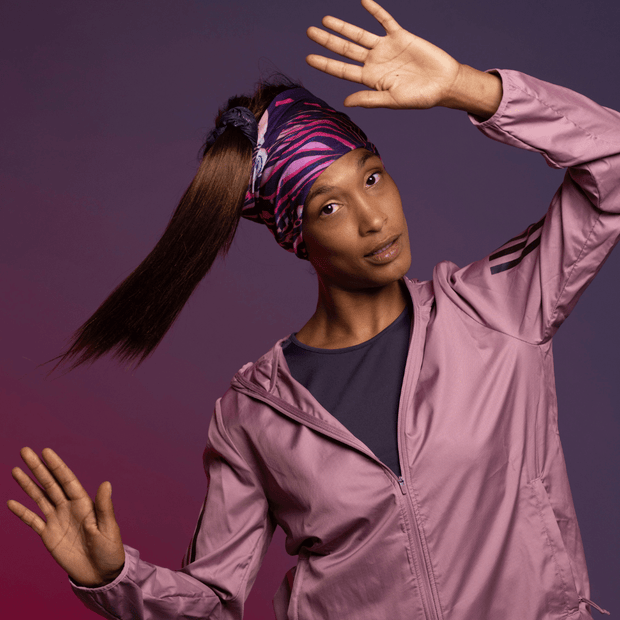 Sportive woman wearing the Magenta Owl Multifunctional bandana as headband. Artwork by Julie Rocheleau for the Lalita's Art Shop 24 collection.