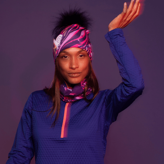 Woman wearing the Magenta Owl multifunctional tube with the assorted pompom beanie by Julie Rocheleau for Lalita&