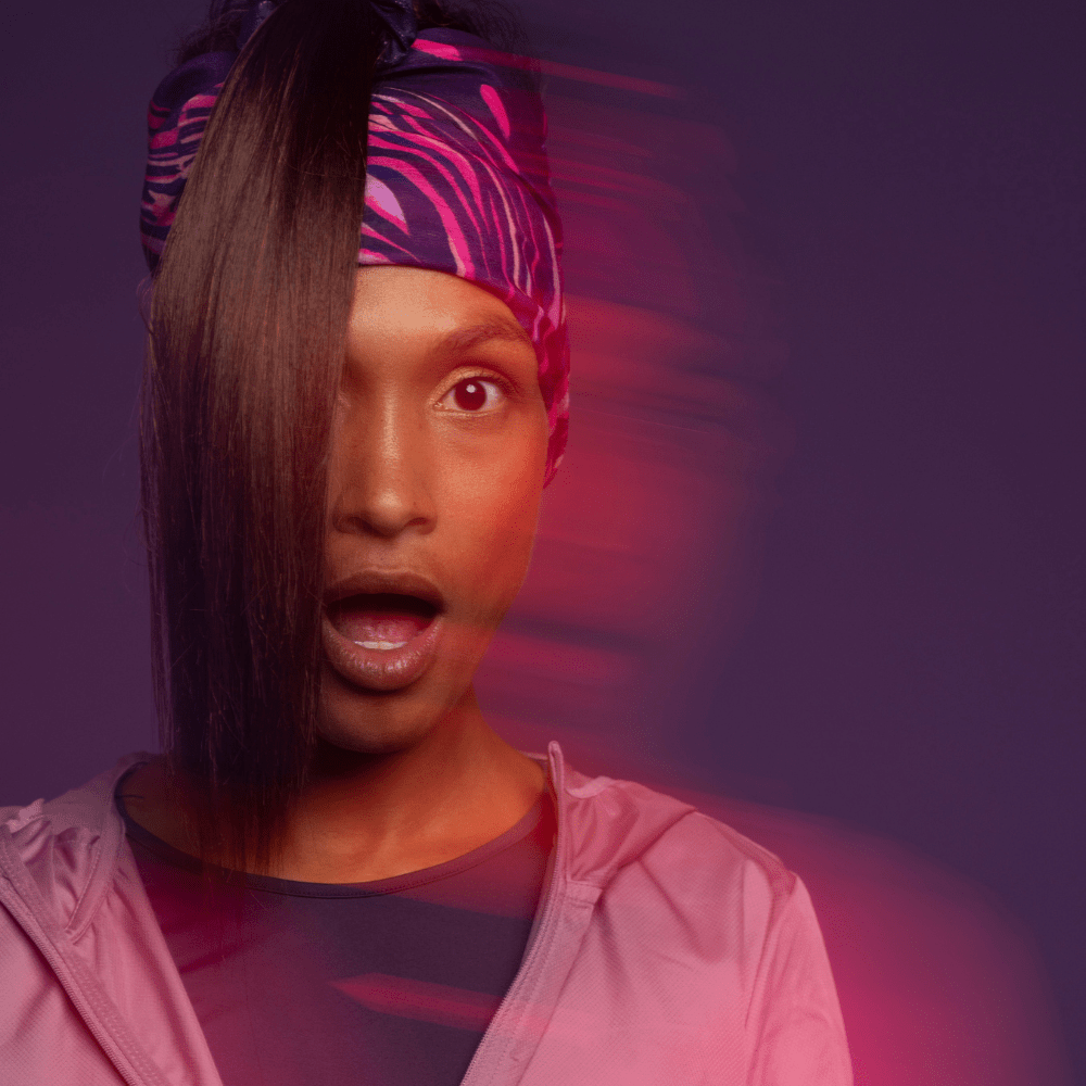 Woman making a surprised face and wearing the Magenta Owl Multifunctional tube as headband for the Lalita&
