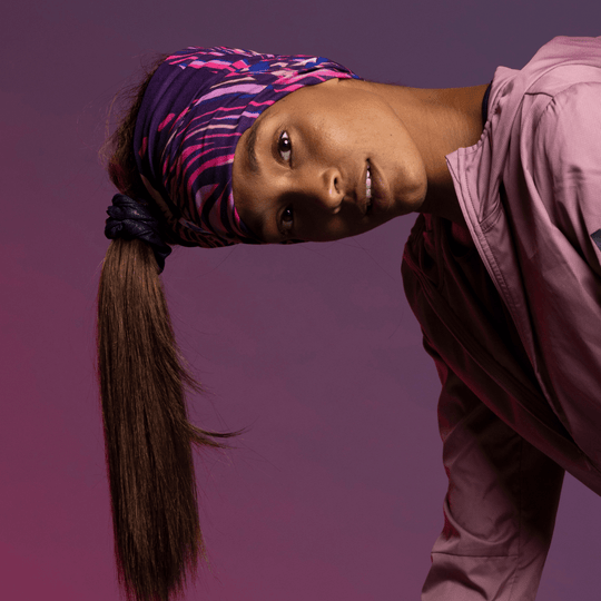 Sportive woman with long hair and ponytail wearing the Magenta Owl Multifunctional tube as headwear for the Lalita&